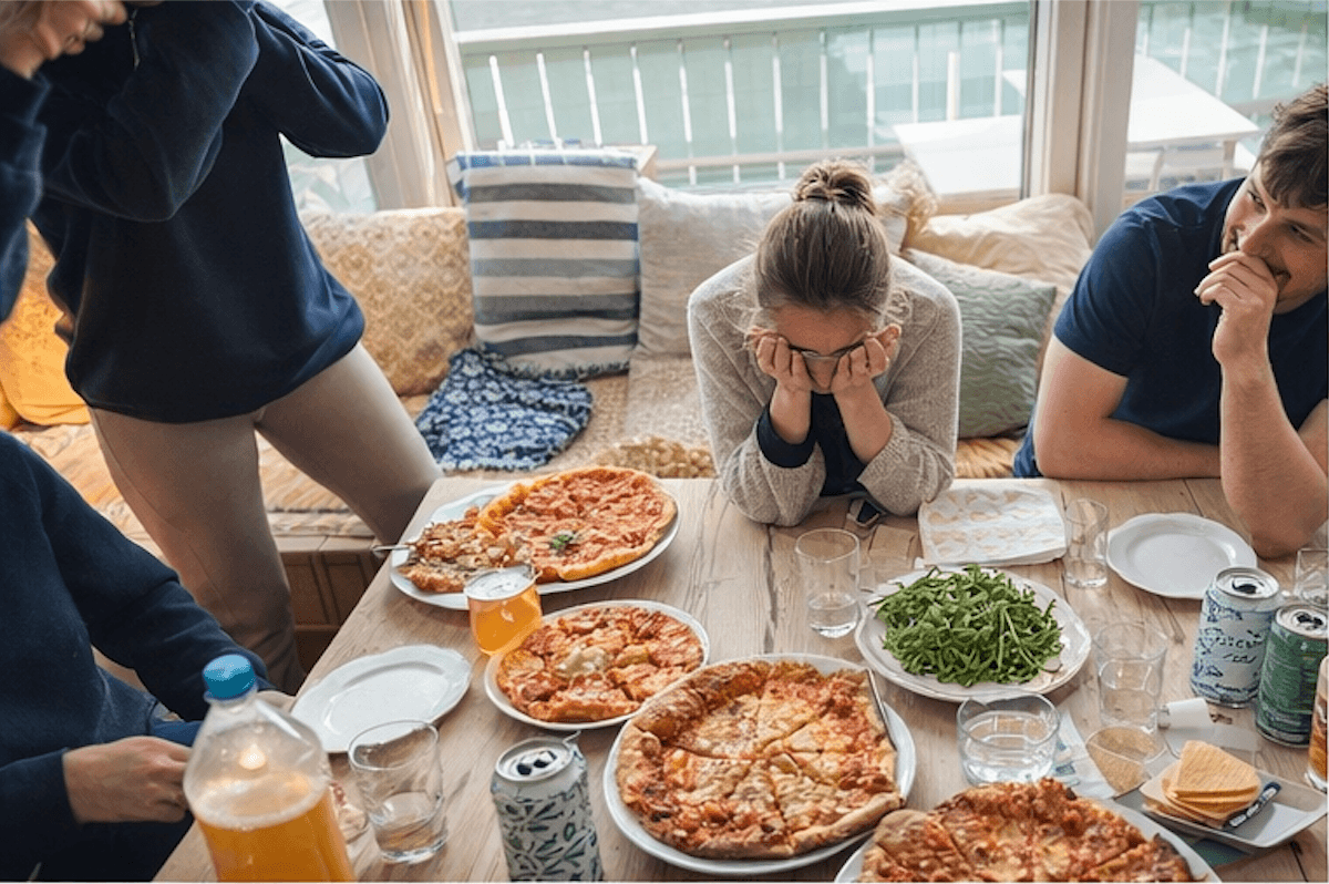 Venner samlet rundt pizzabord pÄ hytta